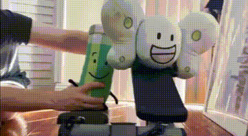 a person is holding two stuffed animals on a exercise bike .