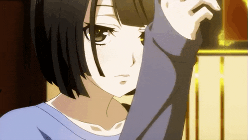 a girl with short black hair is wearing a blue shirt and covering her face with her arm