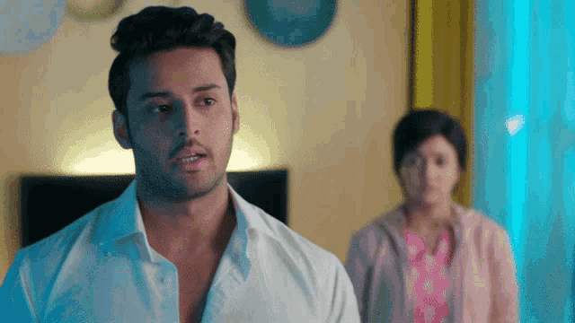 a man in a white shirt is standing in front of a woman