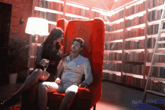 a woman sits on a man 's lap in a library with mayrages written in the corner