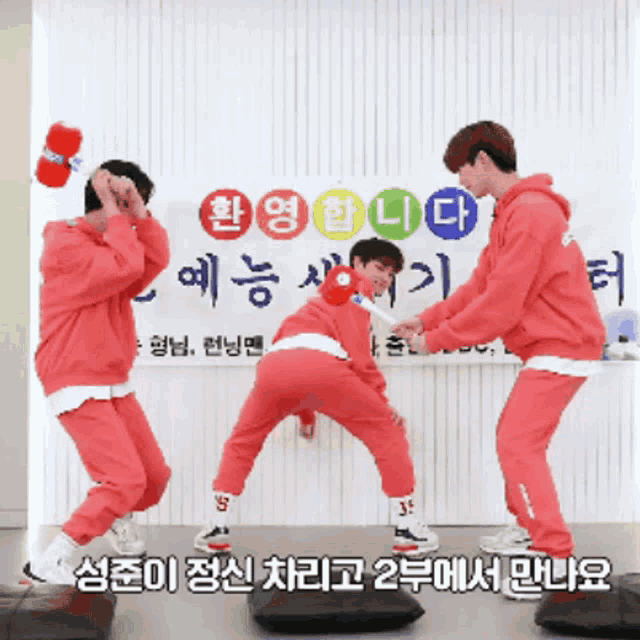 a group of young men are dancing in front of a sign that says ' a ' on it