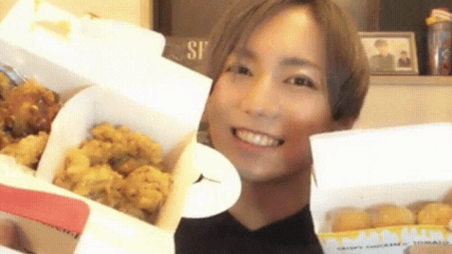 a woman holding a box of fried chicken and a box of chicken nuggets