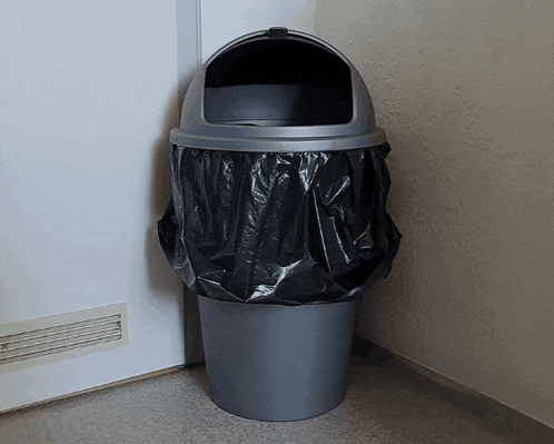 a garbage can with a black bag on it