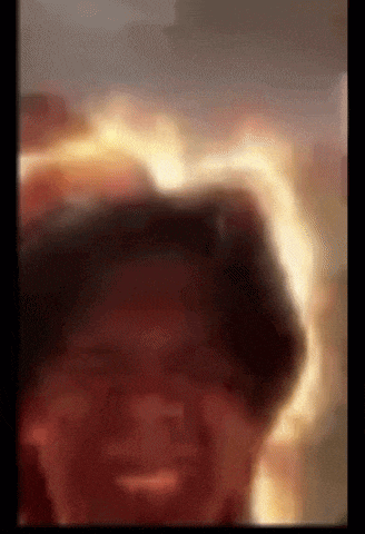 a close up of a person 's face with flames coming out of it