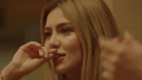 a close up of a woman 's face with a man 's hand covering her mouth