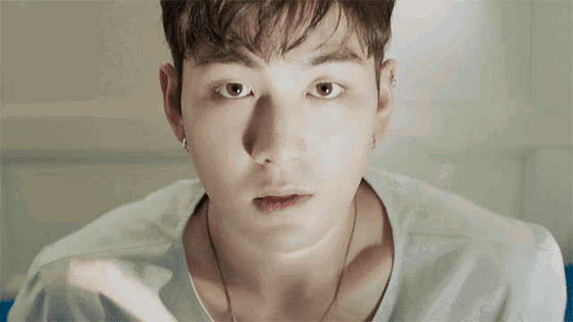 a close up of a person 's face with a white shirt on