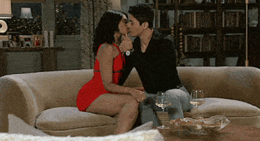 a man and woman are kissing on a couch