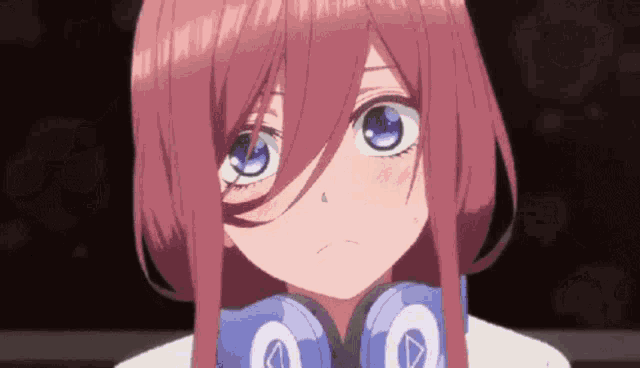 a girl with pink hair and blue eyes is wearing headphones and making a funny face .