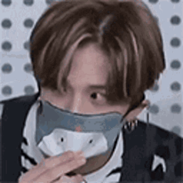 a man wearing a mask with a shark face on it is eating something .