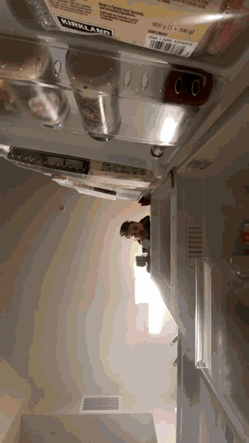an open refrigerator with a kirkland item in the bottom shelf