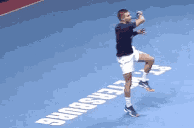 a man is jumping in the air on a tennis court with the word st petersburg written on it