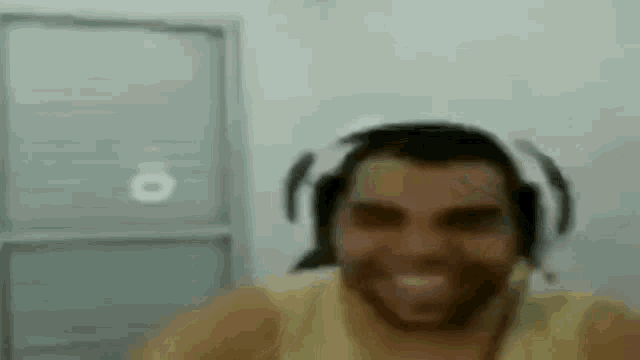 a man wearing headphones and a hat is making a funny face .