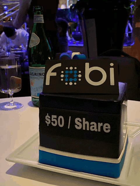 a box that says $ 50 / share sits on a white plate