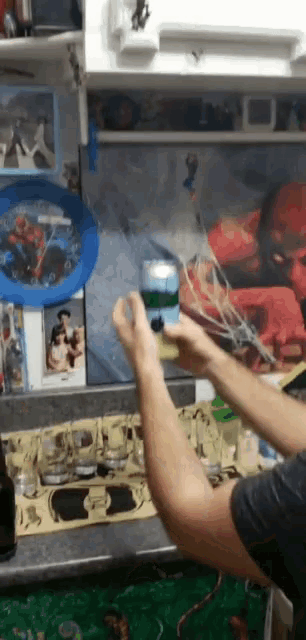 a man is holding a can of soda in front of a painting of a man