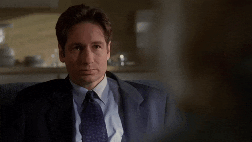 a man in a suit and tie is sitting in a chair