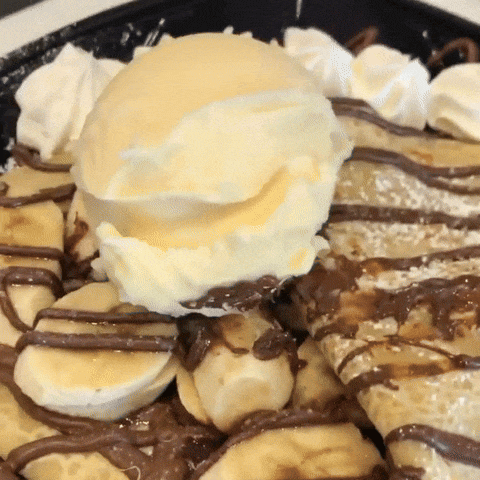 a scoop of vanilla ice cream is on top of a banana crepe