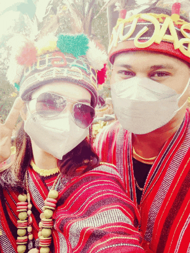 a man and a woman wearing face masks are posing for a picture