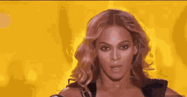 a close up of a woman 's face with a yellow background