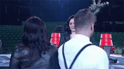a man and a woman are standing next to each other on a stage in front of a microphone .