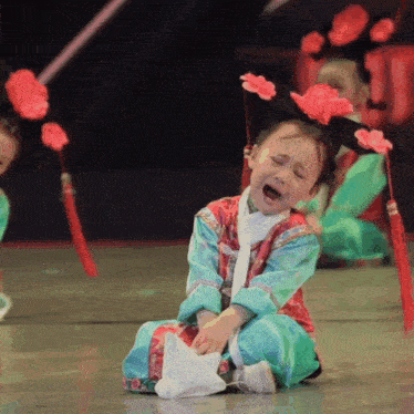 a little girl is crying while wearing a traditional costume