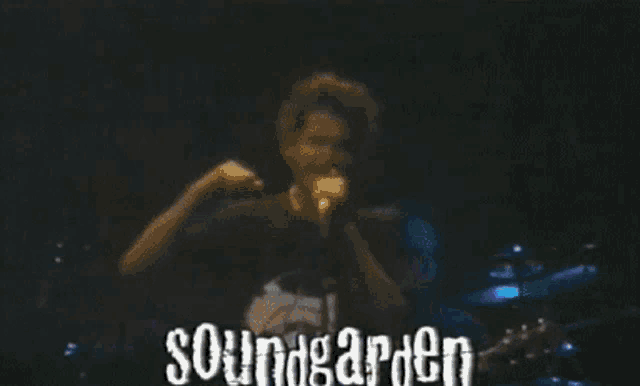 a man singing into a microphone with the words soundgarden written on the bottom