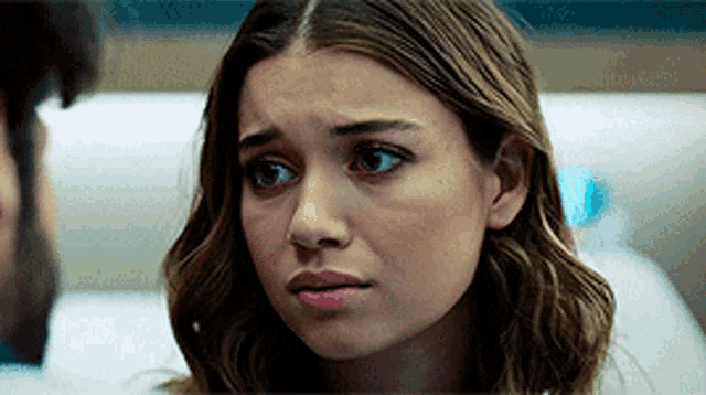 a woman with a sad look on her face is looking at a man .