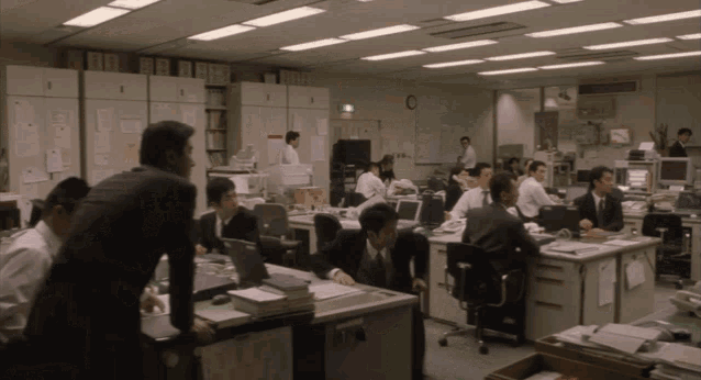 a large office with a clock on the wall that says ' emergency exit '