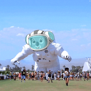 a group of people are gathered around a giant inflatable astronaut balloon
