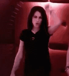 a woman in a black shirt is standing in a red room .