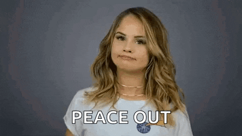 a woman is giving a peace sign with her hands and the words `` peace out '' behind her .