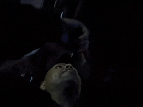 a man is laying on his back in the dark looking up at something