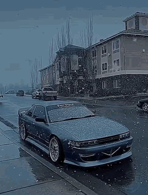 a car is covered in snow on the side of the road .