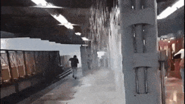 a man is running towards a train on a subway platform .