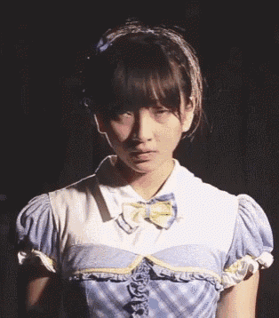 a girl wearing a blue and white dress with a bow