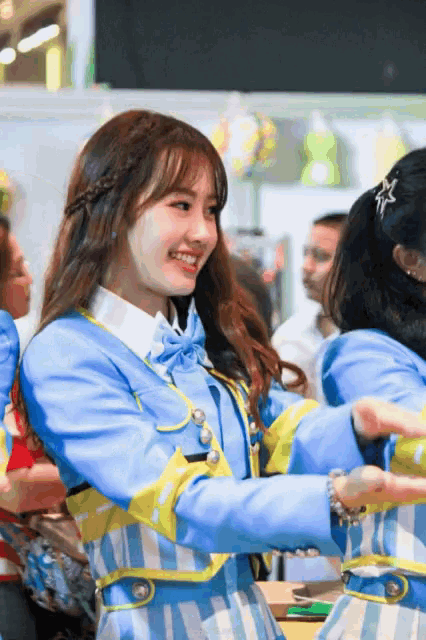a girl in a blue and yellow striped jacket smiles