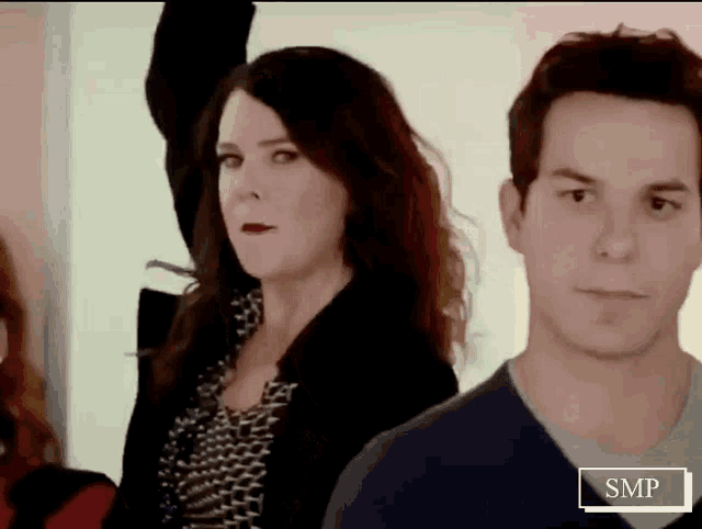 a man and a woman are standing next to each other with smp written on the bottom
