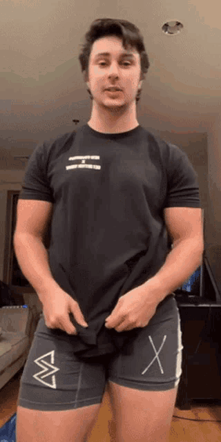 a man wearing a black shirt with the letter h on the front