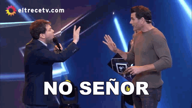 two men on a stage with the words no señor written in white