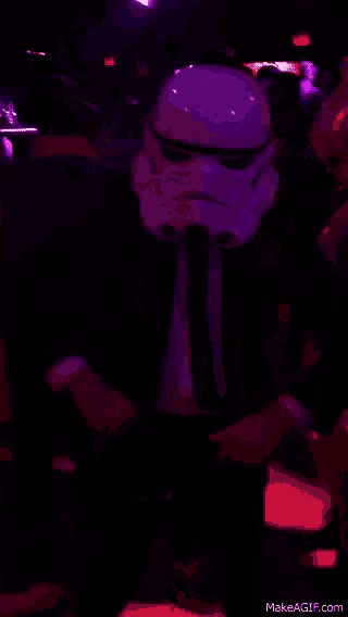 a storm trooper is dancing in a dark room with purple lights behind him