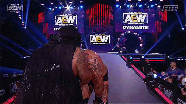 a wrestler is walking down the aisle of a aew wrestling event