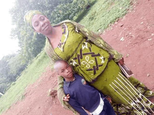 a woman is standing next to a boy in a field .
