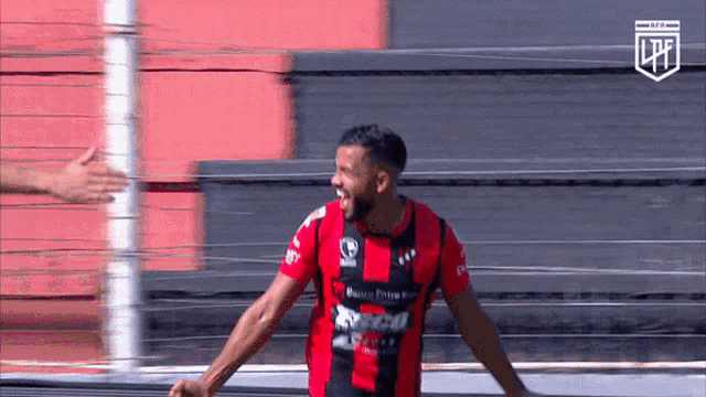 a soccer player in a red and black jersey with a lpf logo on the bottom
