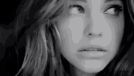 a close up of a woman 's face in a black and white photo with a surprised look on her face .