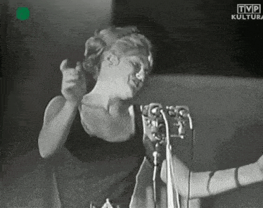 a woman singing into a microphone with tvp kultura written on the bottom right