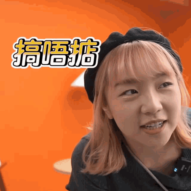 a girl with pink hair is wearing a black hat with chinese characters on it