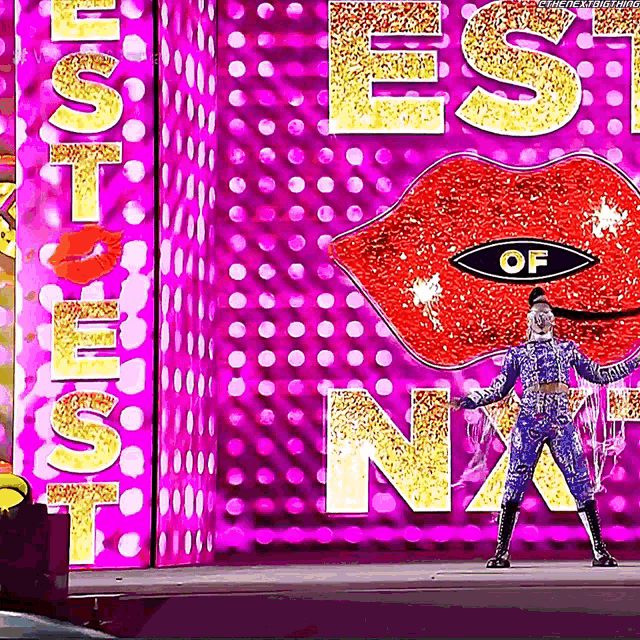 a woman in a blue outfit is standing in front of a sign that says ' best of n.a. '