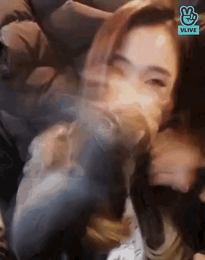 a blurry picture of a woman with a vlive logo in the corner