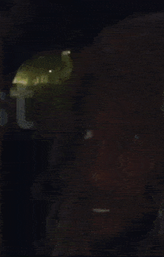 a close up of a man 's face in a dark room with a blurred background .
