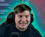 a man wearing headphones and a microphone is sitting in front of a computer screen .