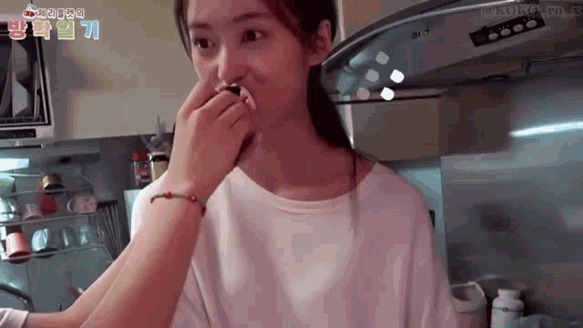a woman in a white shirt is being kissed by another woman in a kitchen ..
